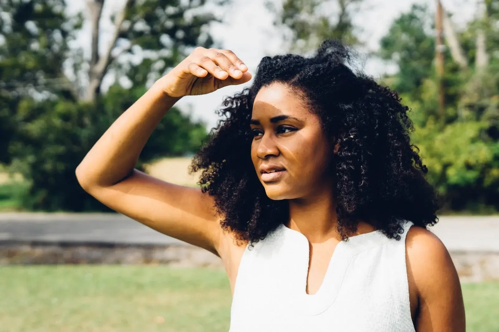 Dr. Allison J. McDade, MD, outdoors in the sun, shading her eyes and looking ahead