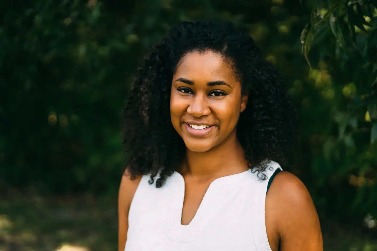Dr. Allison J. McDade, MD, smiling outdoors in front of green trees